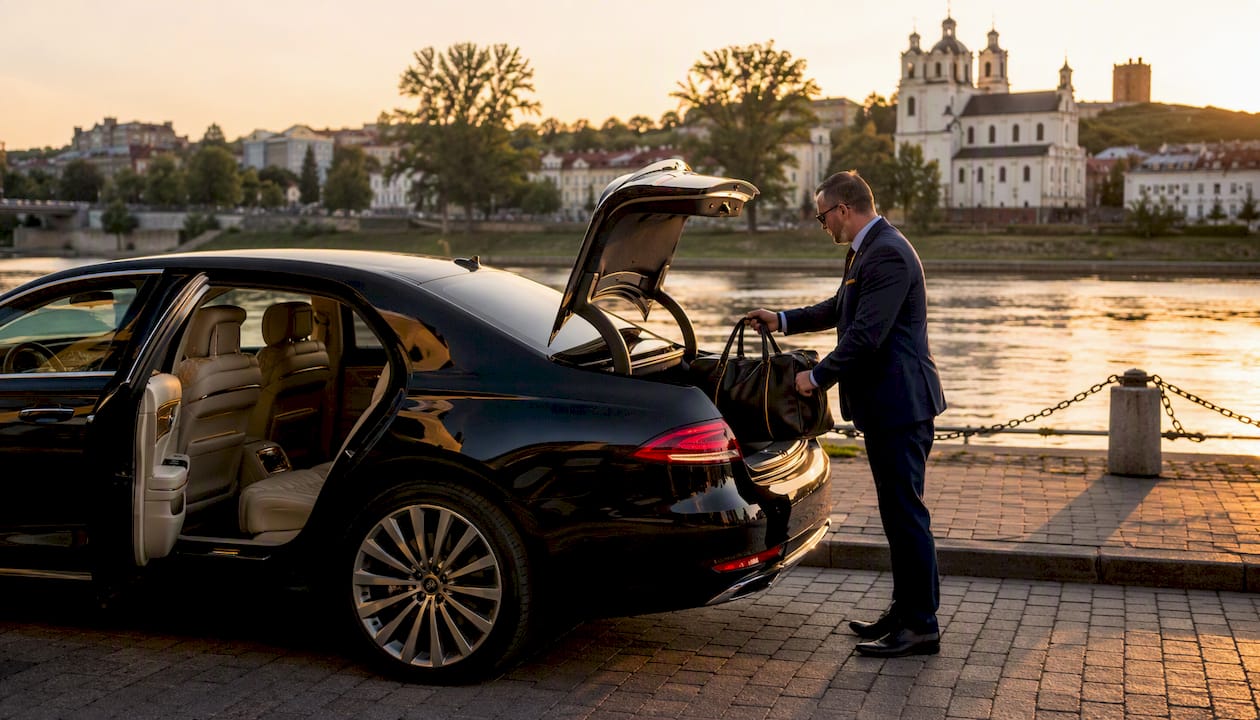 Luxury sedan with chauffeur open door Tallinn street
